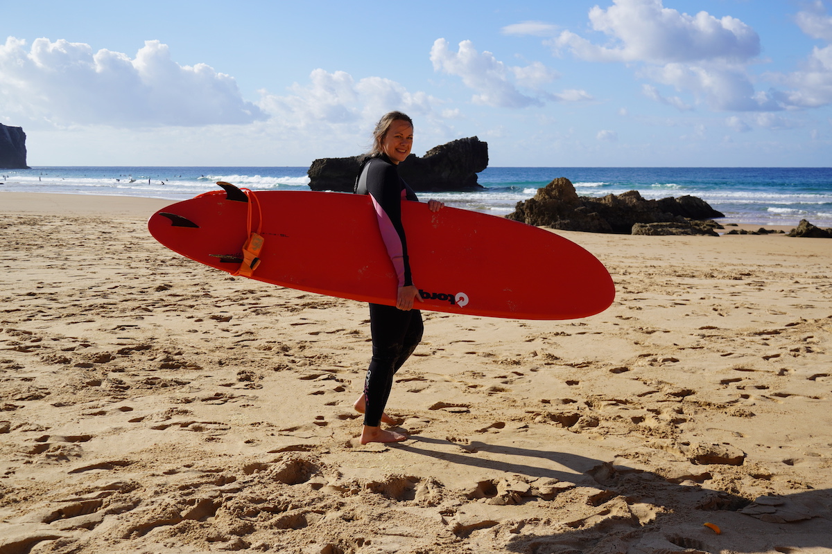 Ramona Beyer on the beach with a big red surfboard